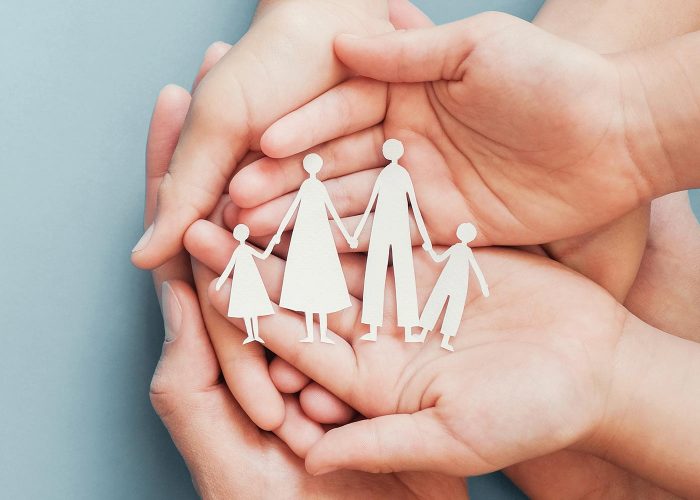 Hands holding paper figures